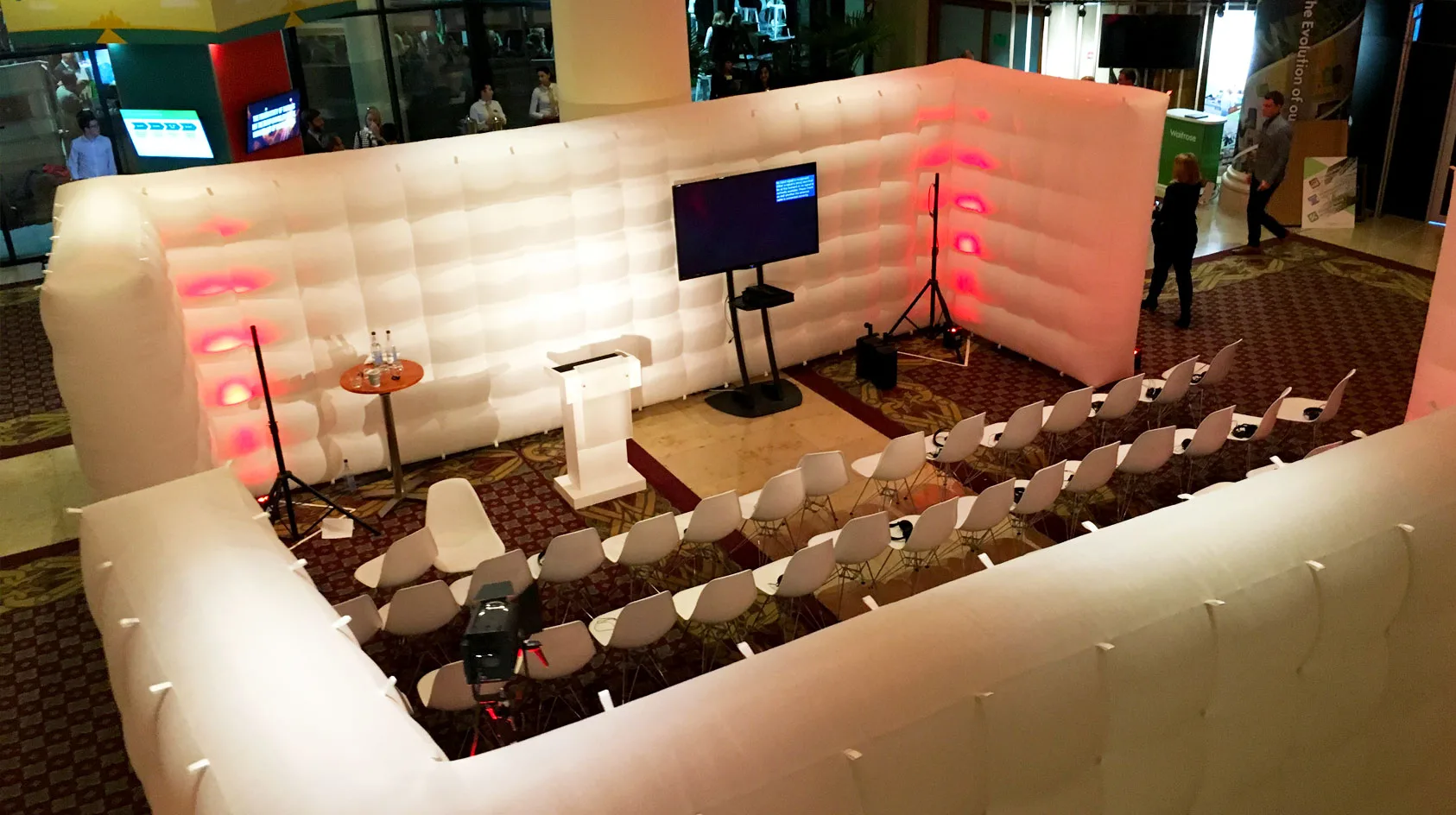 Pic showing two Created By Air Cubewall modular inflatable structures  setup to enclose a presentation seating area and screen