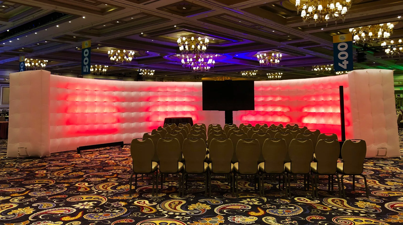 Pic showing a Created By Air C wall illuminated with red LED lighting and presentation seating set out in front