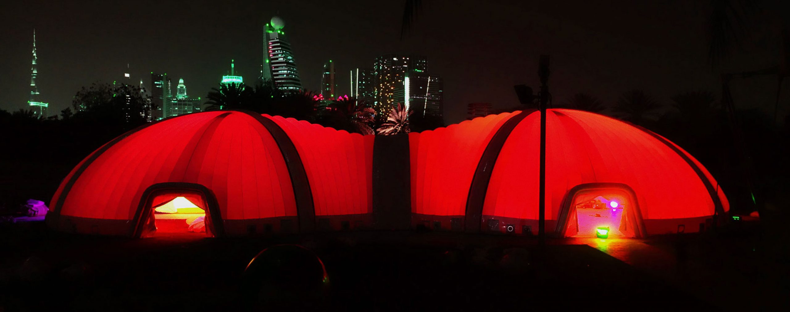 Pic showing a Created By Air peanut outdoor inflatable structure illuminated with red LED lighting at night