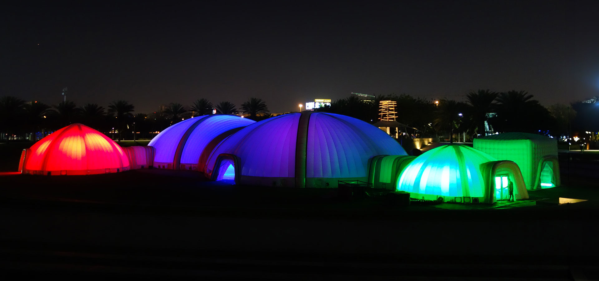 Pic showing a configuration of different shaped and sized Created By Air inflatable structures connected together at an event in Dubai illuminated in different colours at night